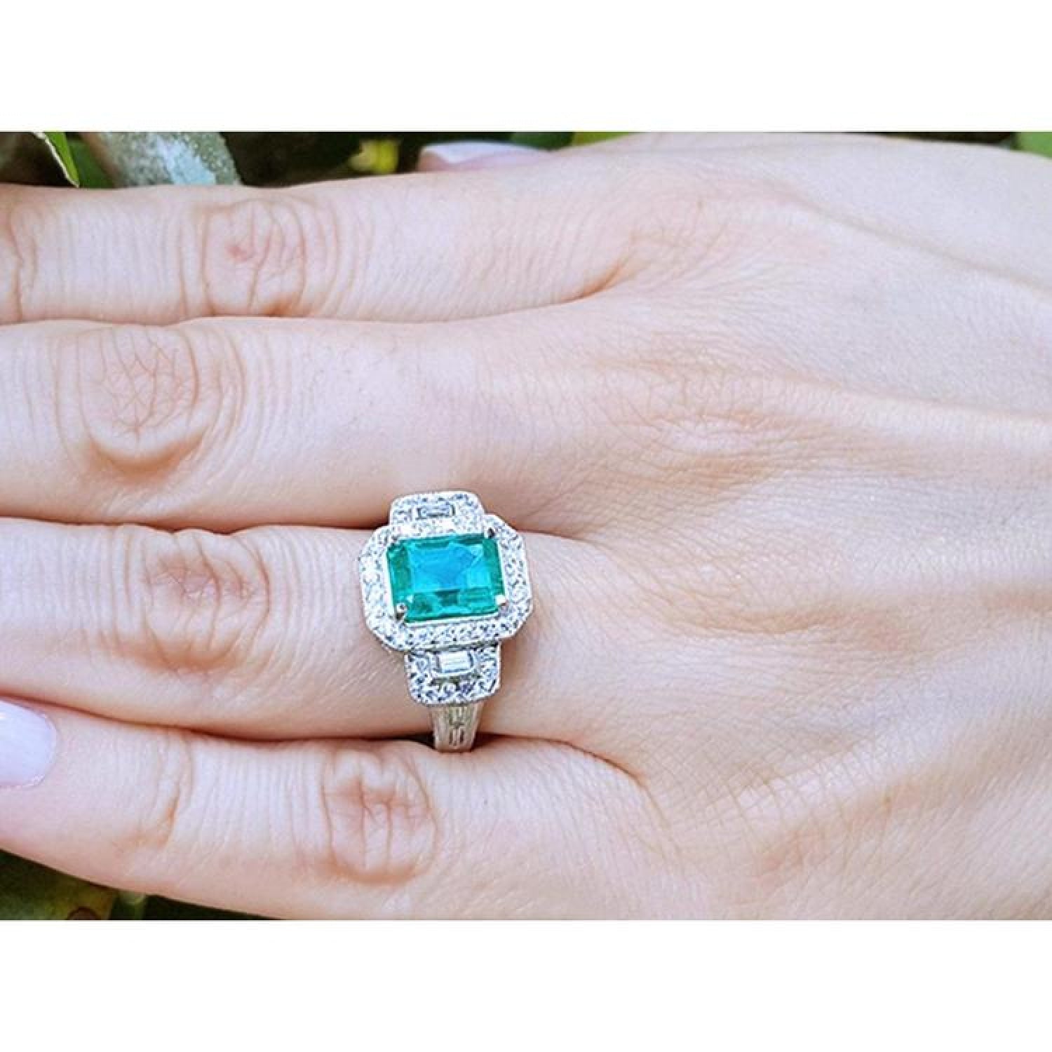 2.47 ct GIA certified F1 emerald engagement ring with diamond halo and baguette side diamonds in 18K white gold.