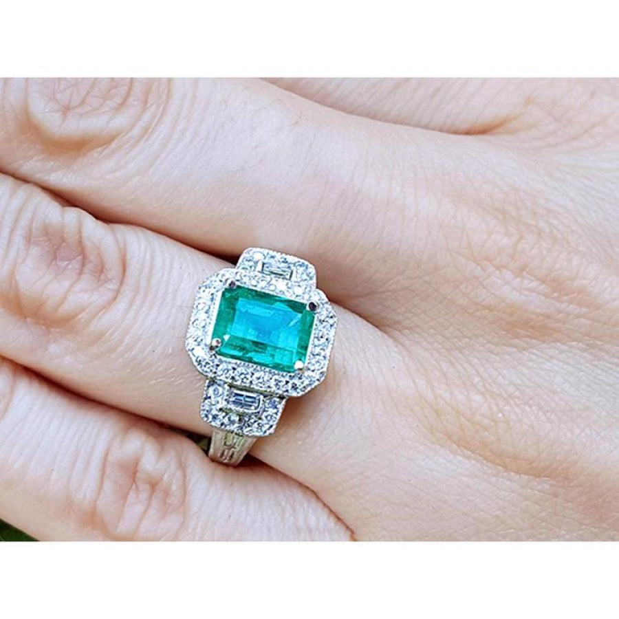 2.47 ct. GIA certified F1 emerald engagement ring in 18K white gold with diamond halo and baguette side diamonds.