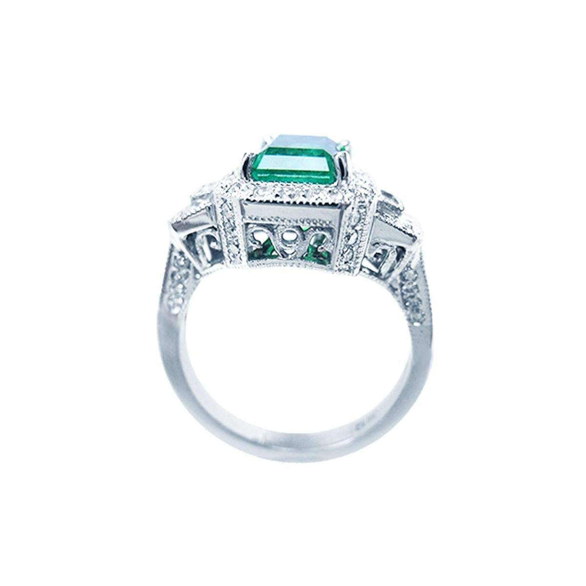 A 18k white gold natural emerald ring on a lateral position with top and gallery view.