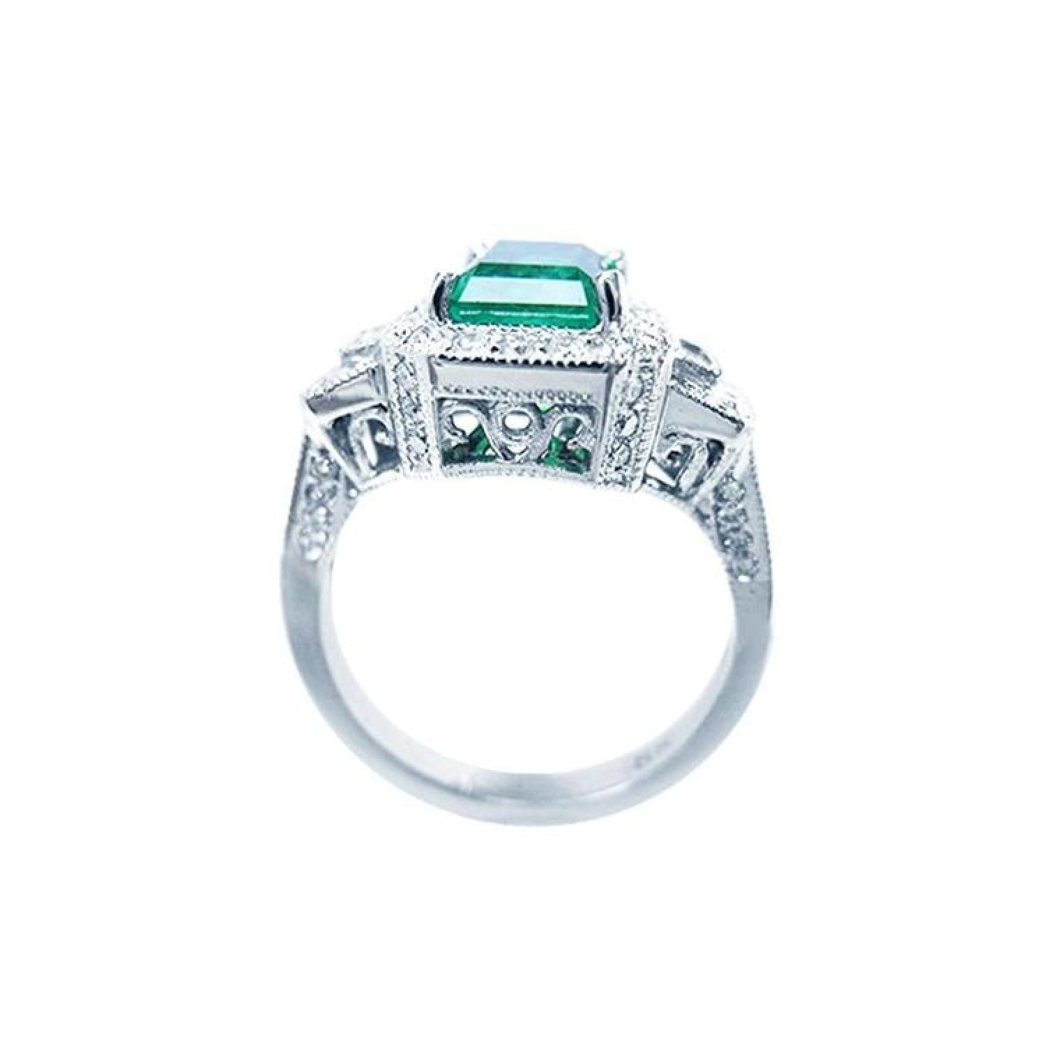 18K white gold engagement ring with a vibrant emerald, diamond halo, and baguette side diamonds.