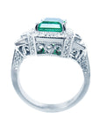 A 18k white gold natural emerald ring on a lateral position with top and gallery view.