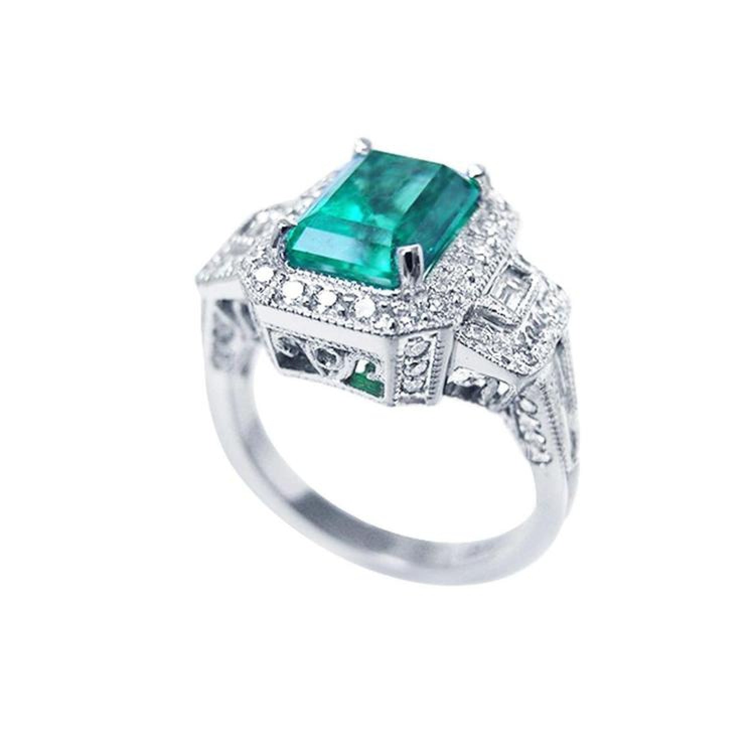 Vibrant 2.47 ct. emerald engagement ring in 18K white gold with diamond halo and baguette side diamonds.