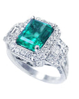 A 18k white gold emerald ring with accent natural diamonds on a top and side profile view.