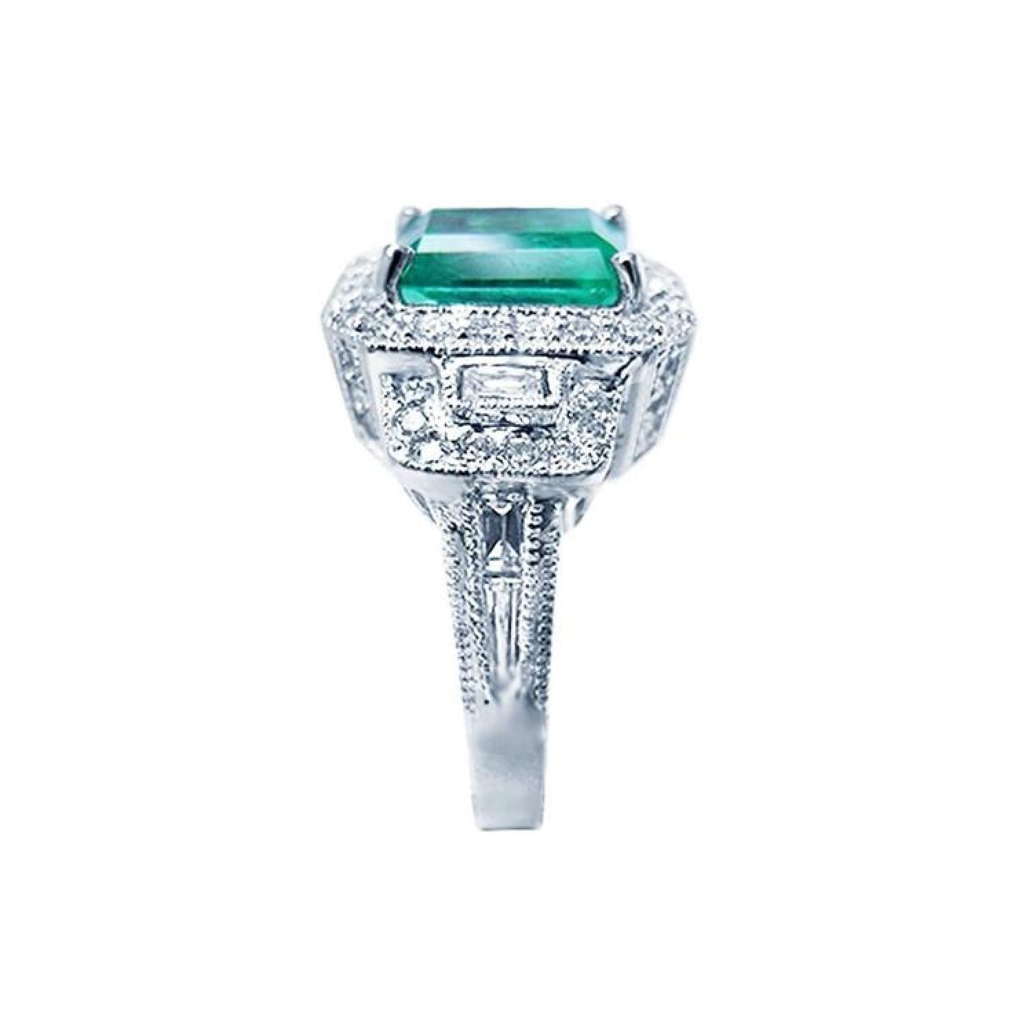 Vibrant 2.47 ct. emerald engagement ring in 18K white gold with diamond halo and baguette side diamonds.
