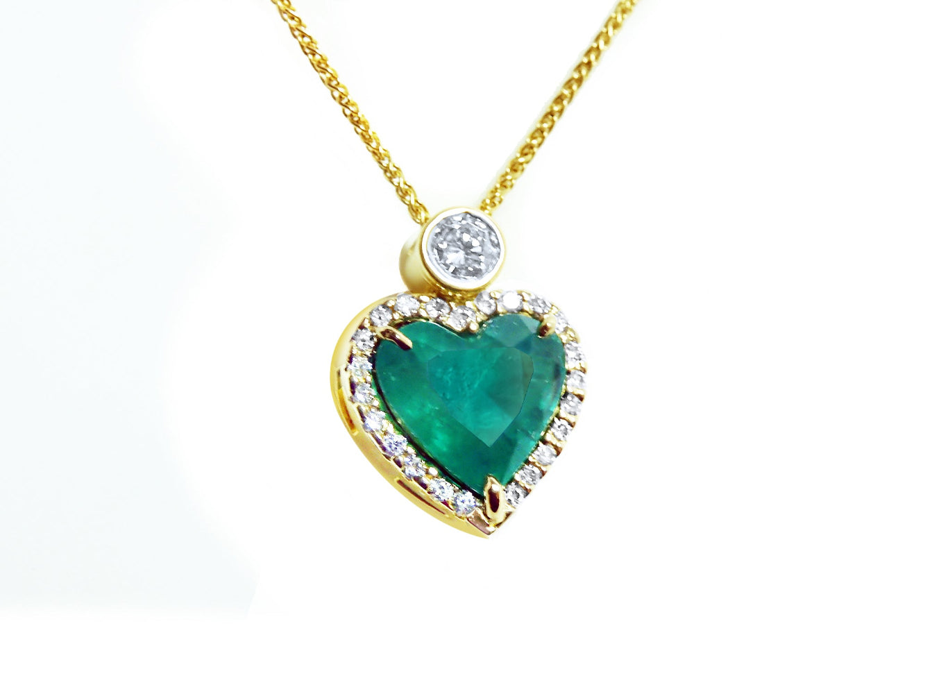 Heart-shaped pendant with a natural emerald and gold chain on topside view position.