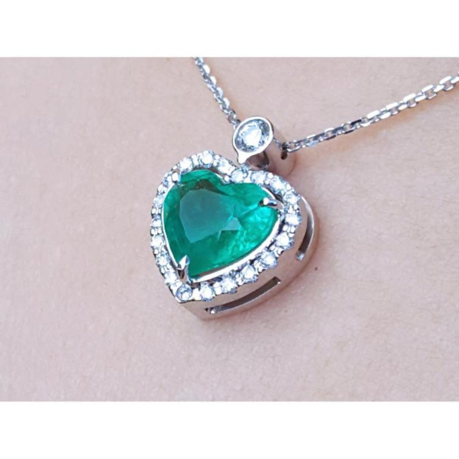 2.64 ct natural emerald heart pendant in 14K white gold, framed by diamonds on a delicate chain.