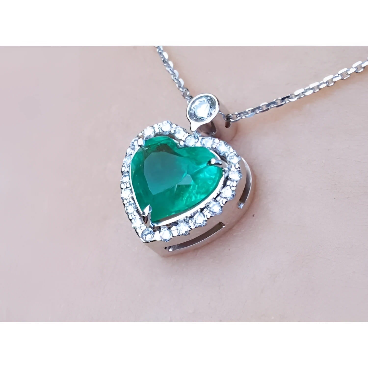 2.64 ct natural emerald heart pendant in 14K white gold, framed by diamonds on a delicate chain.