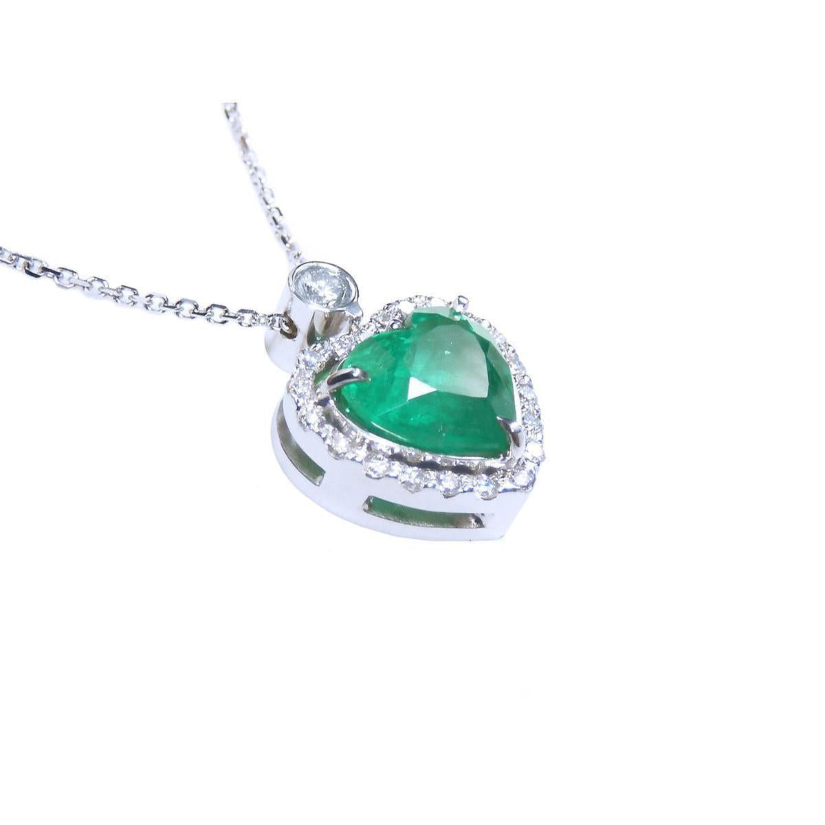 Heart-shaped emerald pendant with diamond accents on a toside anda gallery profile view.