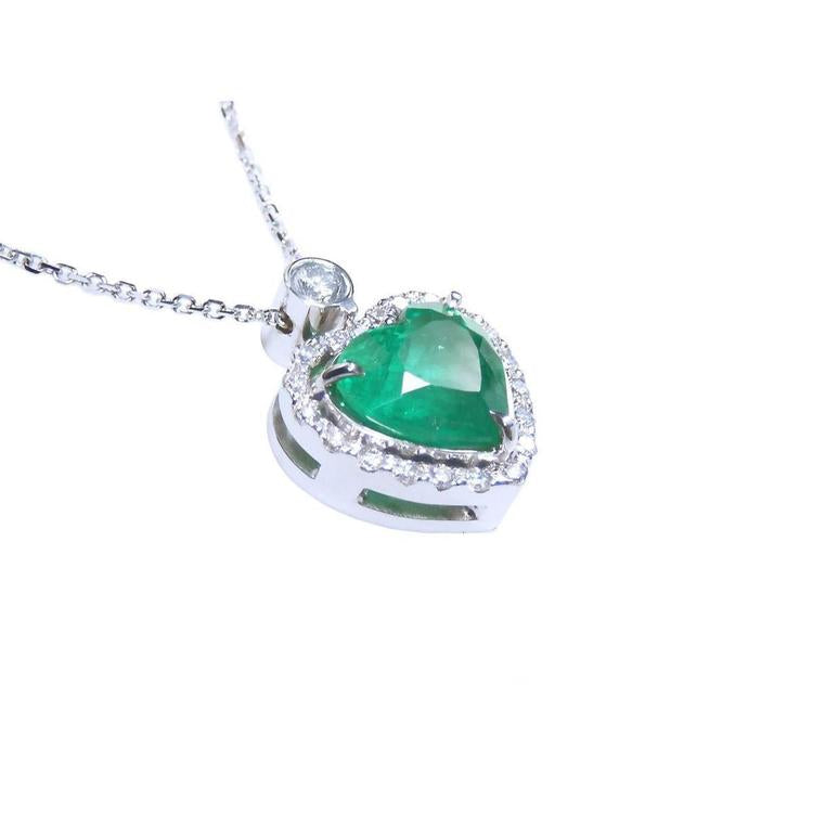 Heart-shaped emerald pendant with diamond accents on a toside anda gallery profile view.
