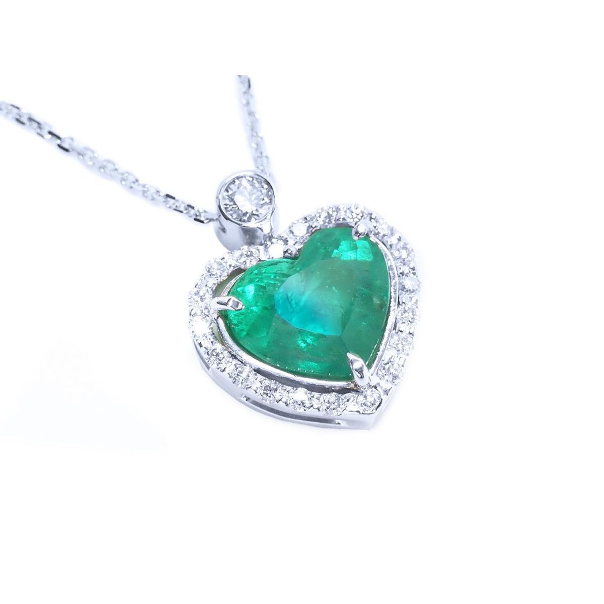 Heart-shaped emerald pendant with diamond accents on a toside view position