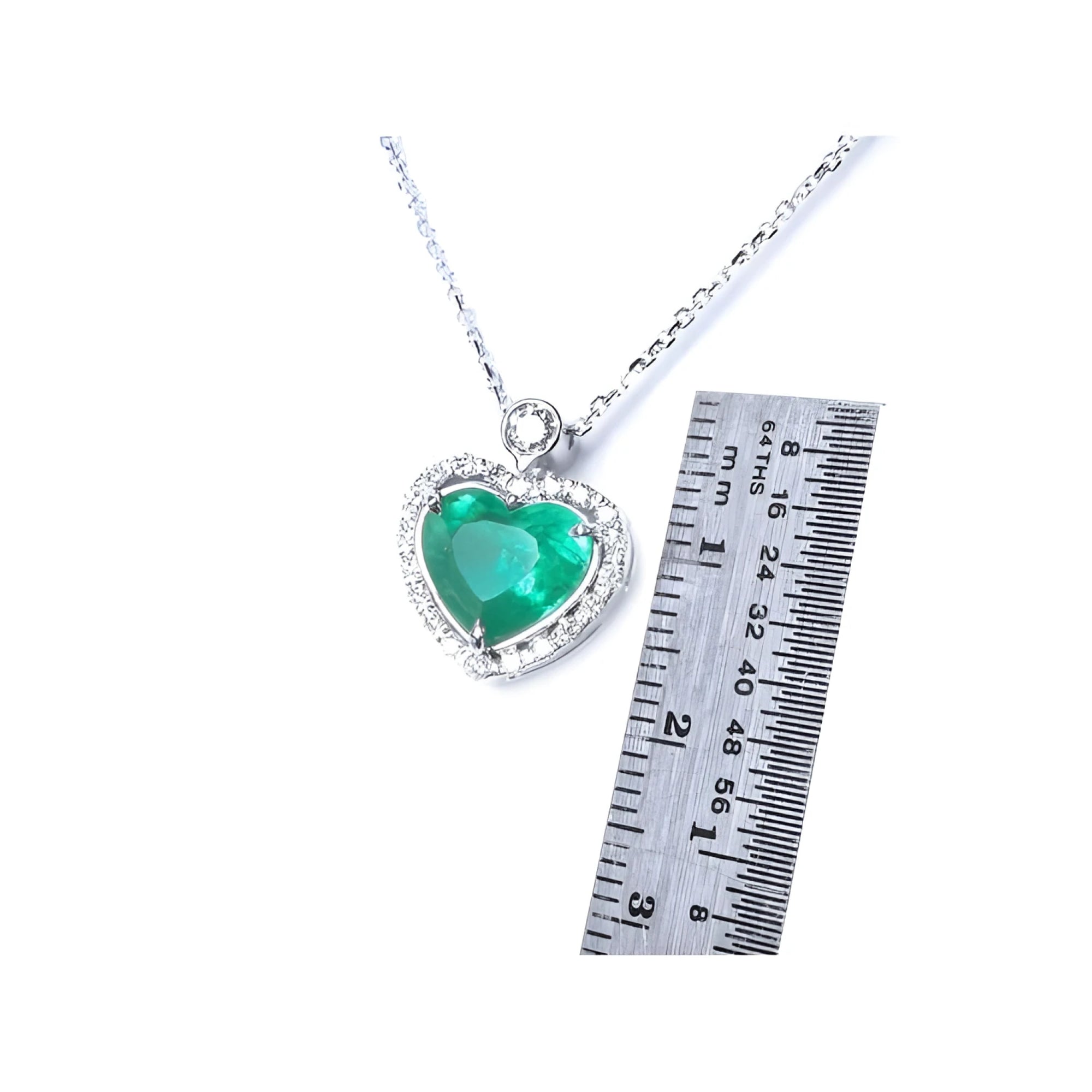 Emerald heart pendant in 14K white gold with diamond halo, shown next to a ruler for scale.