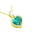 Heart-shaped emerald pendant with gold frame and halo of natural diamond accents. 