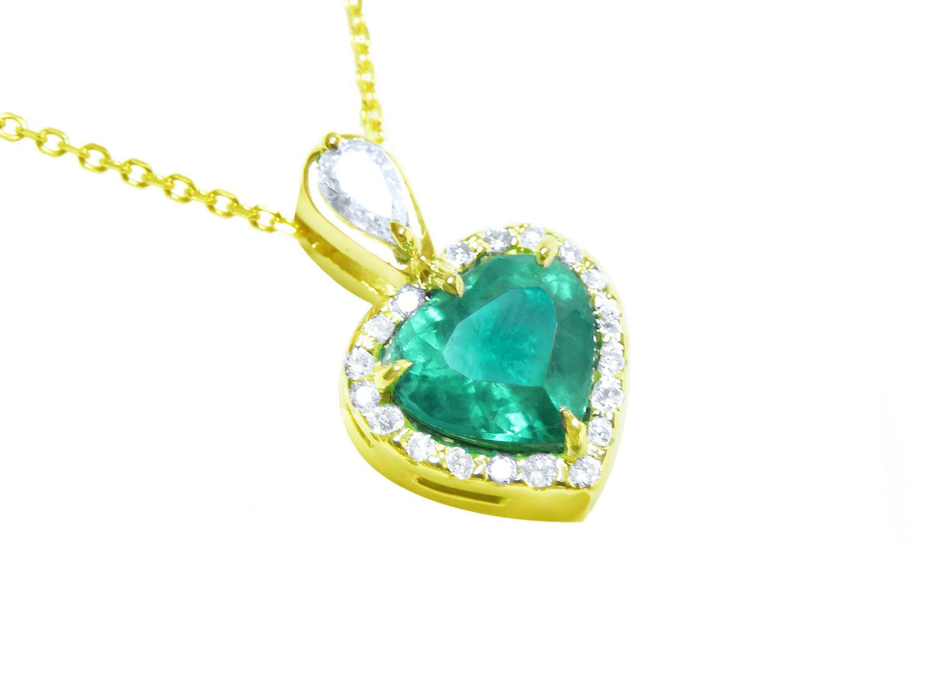 Heart-shaped emerald pendant with gold frame and diamond accents on a topside position view.