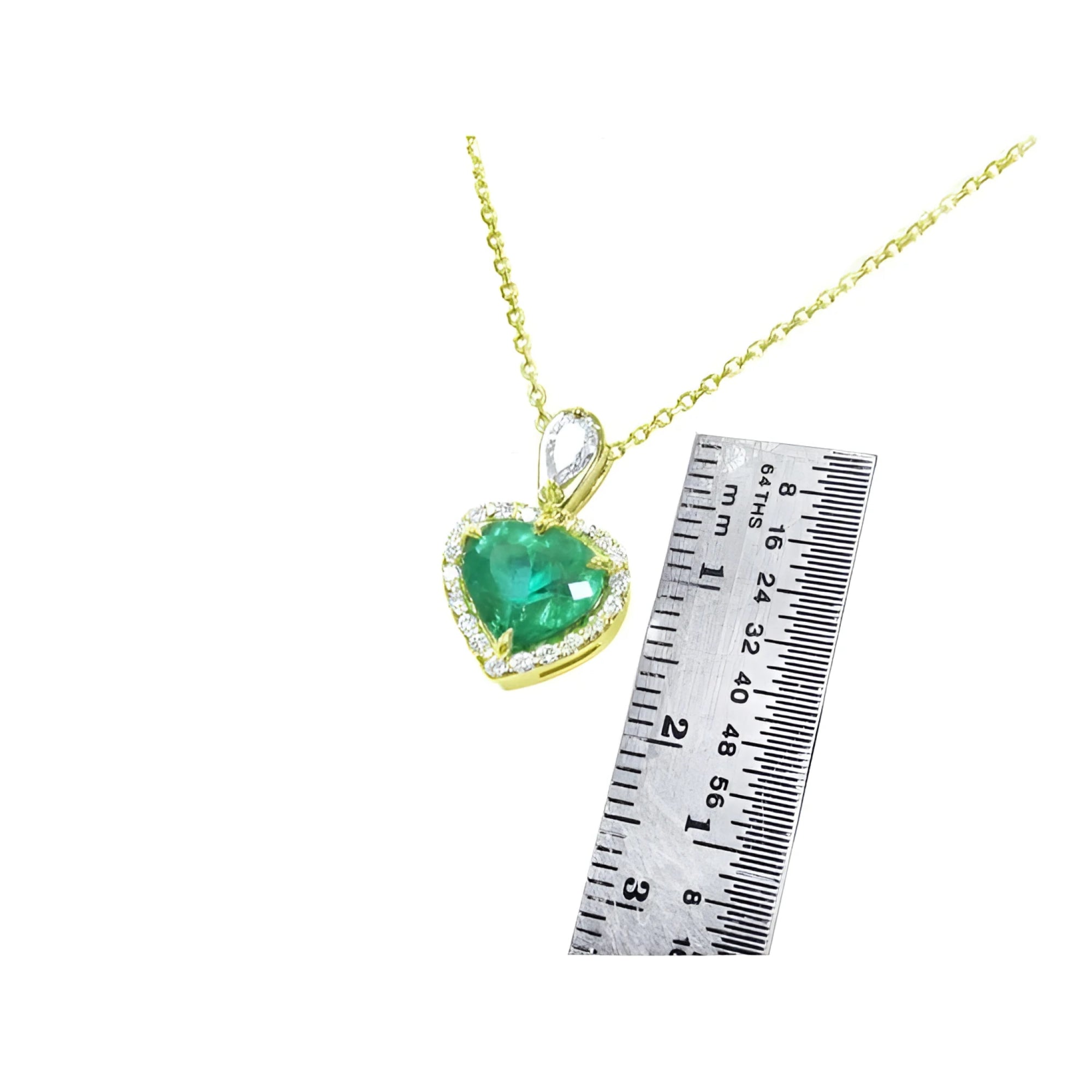 14K yellow gold heart pendant with a deep green emerald and diamond halo, next to a ruler.