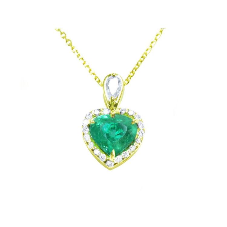 Heart-shaped emerald pendant with gold and diamonds frame on a white background.