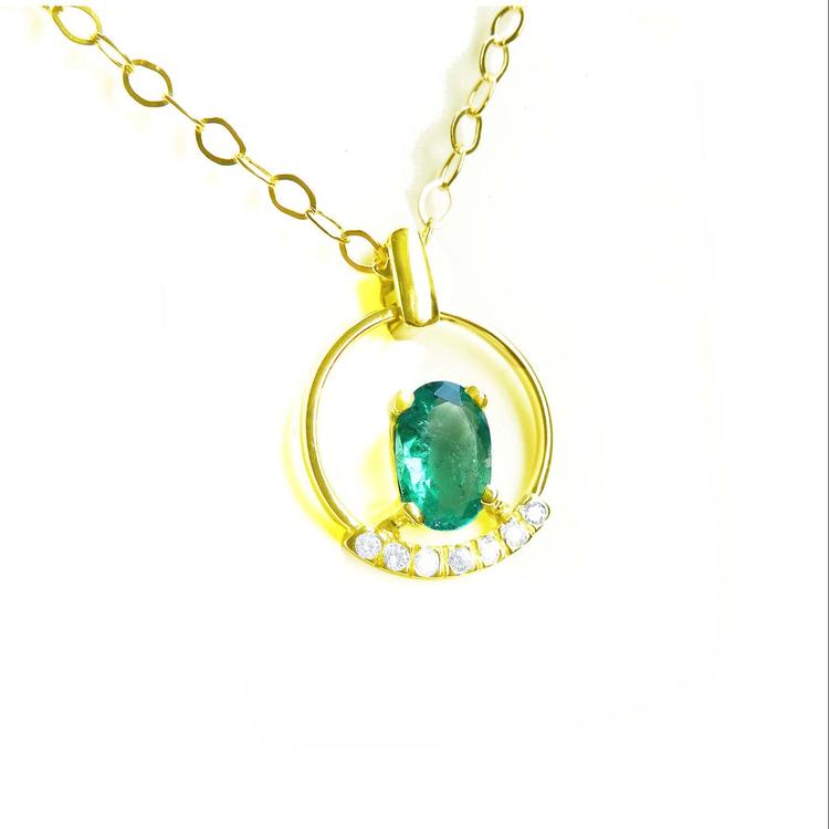Oval cut natural colombian emerald in 14k yellow gold necklace with diamonds.