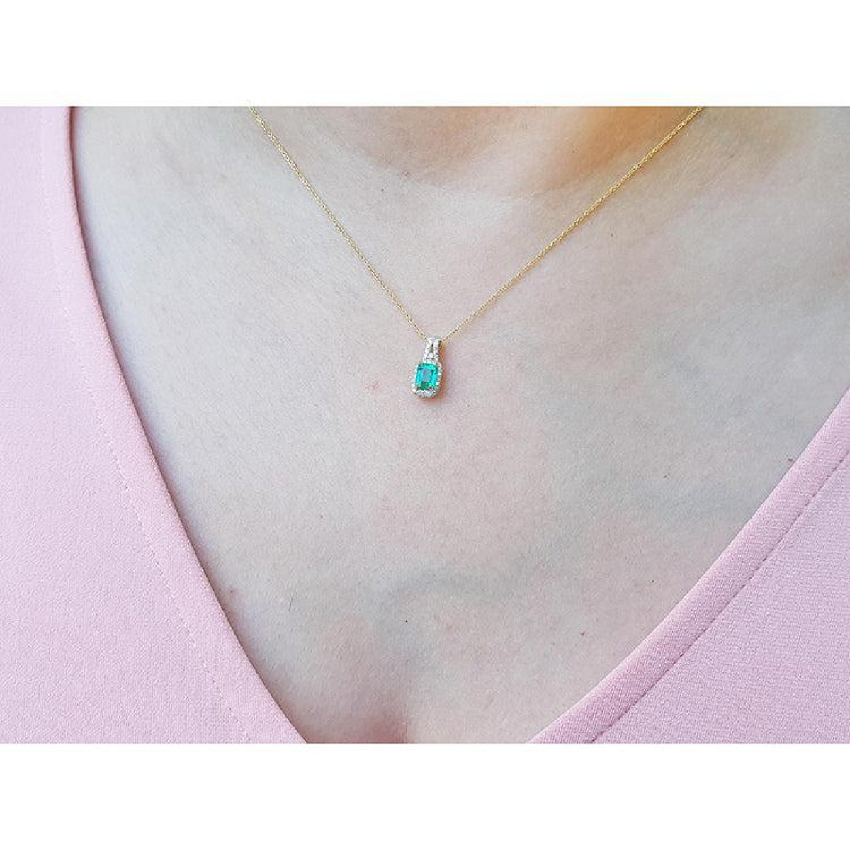 Emerald cut Colombian emerald slider pendant with halo diamonds on a delicate 14K gold chain.