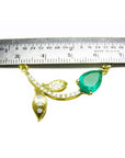 14K yellow gold twig necklace with a pear-cut Colombian emerald and diamond accents, measured by a ruler.
