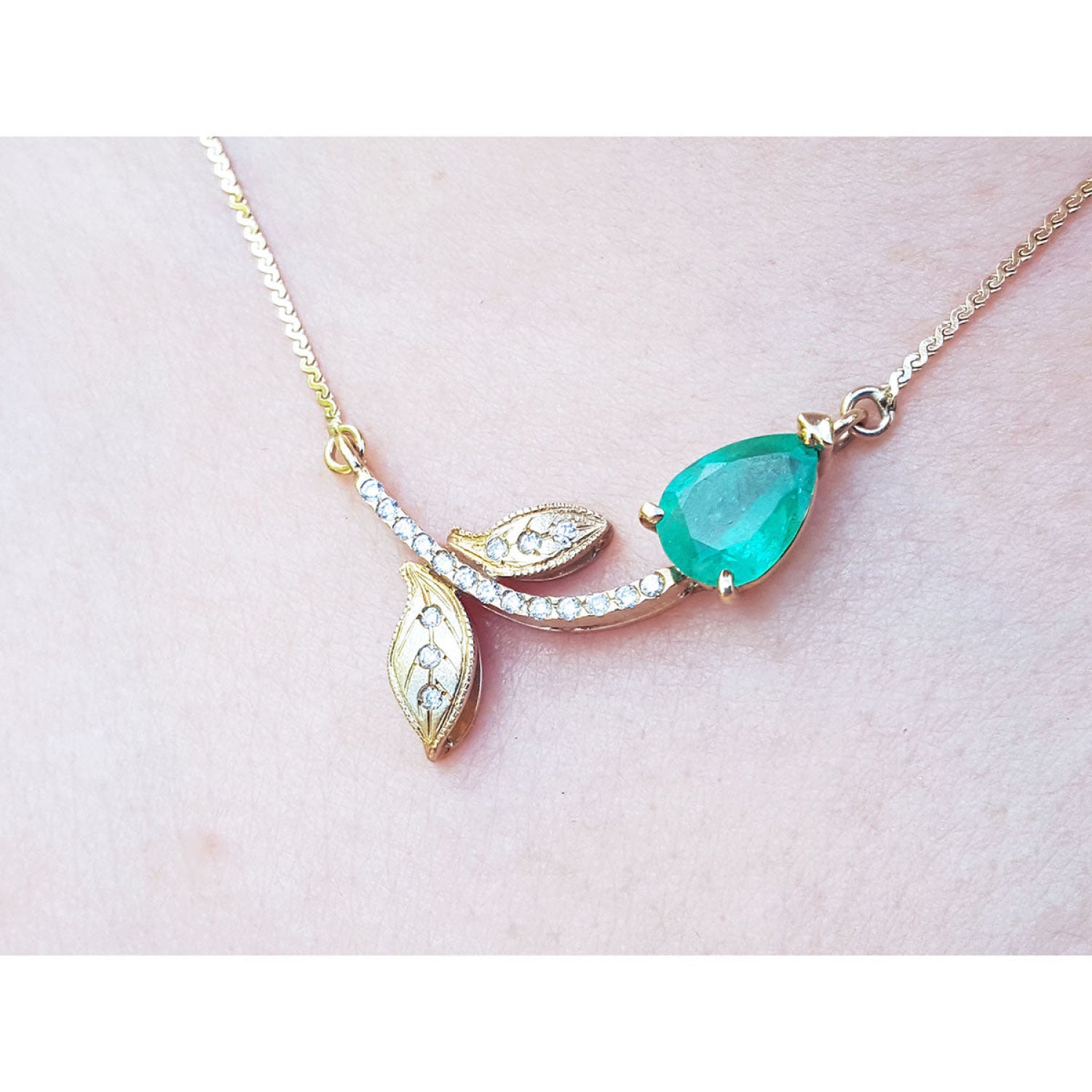 14K yellow gold twig necklace with a pear-cut natural emerald and diamond accents.