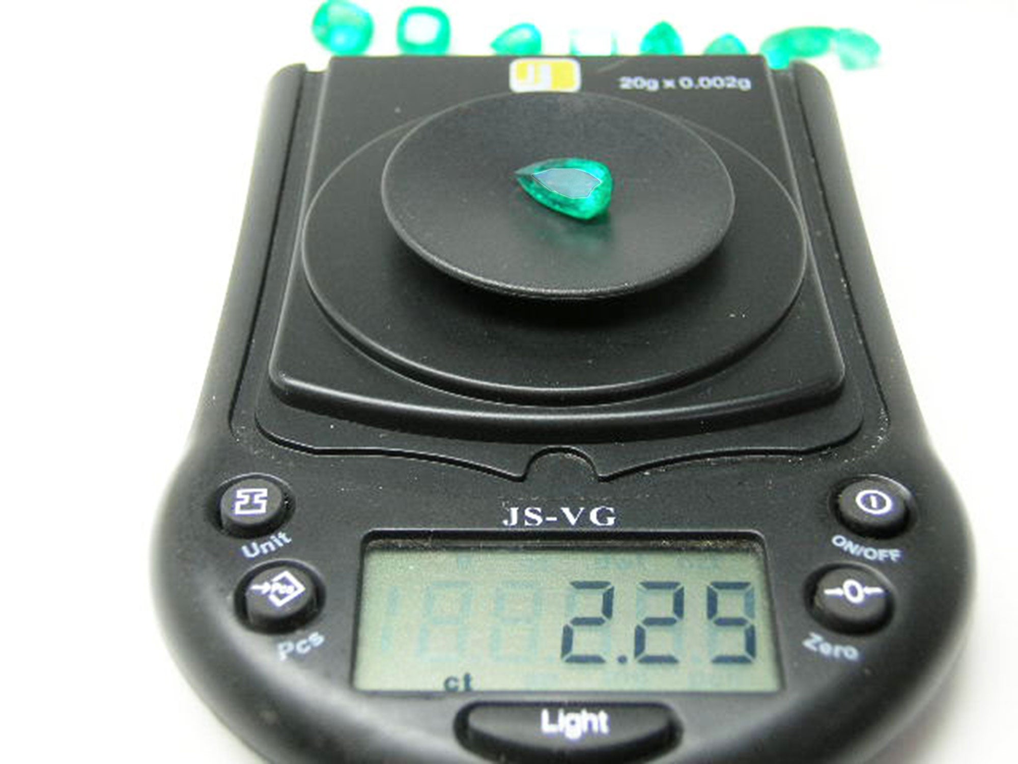 Natural emerald pear cut from muzo mine Colombia, on electronic scale weight