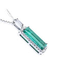 An elongated emerald pendant with side galley view, halo diamonds in 18k white gold.