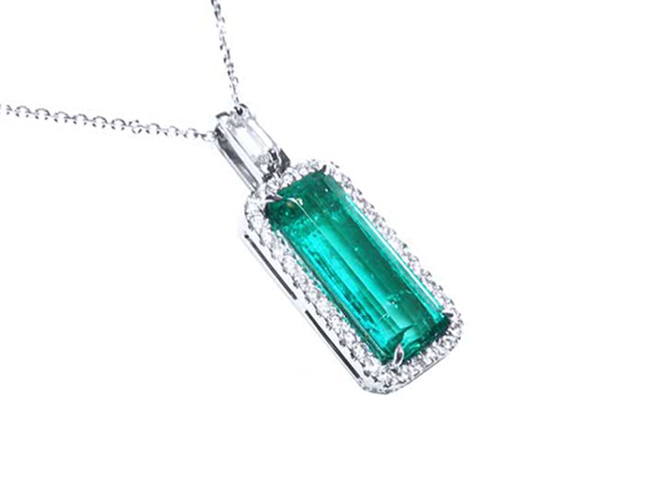 Emerald green gemstone pendant with diamond accents on a white background