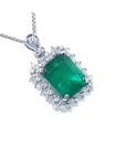 A Colombian emerald pendant necklace with halo natural diamond in 14k white gold topside view.