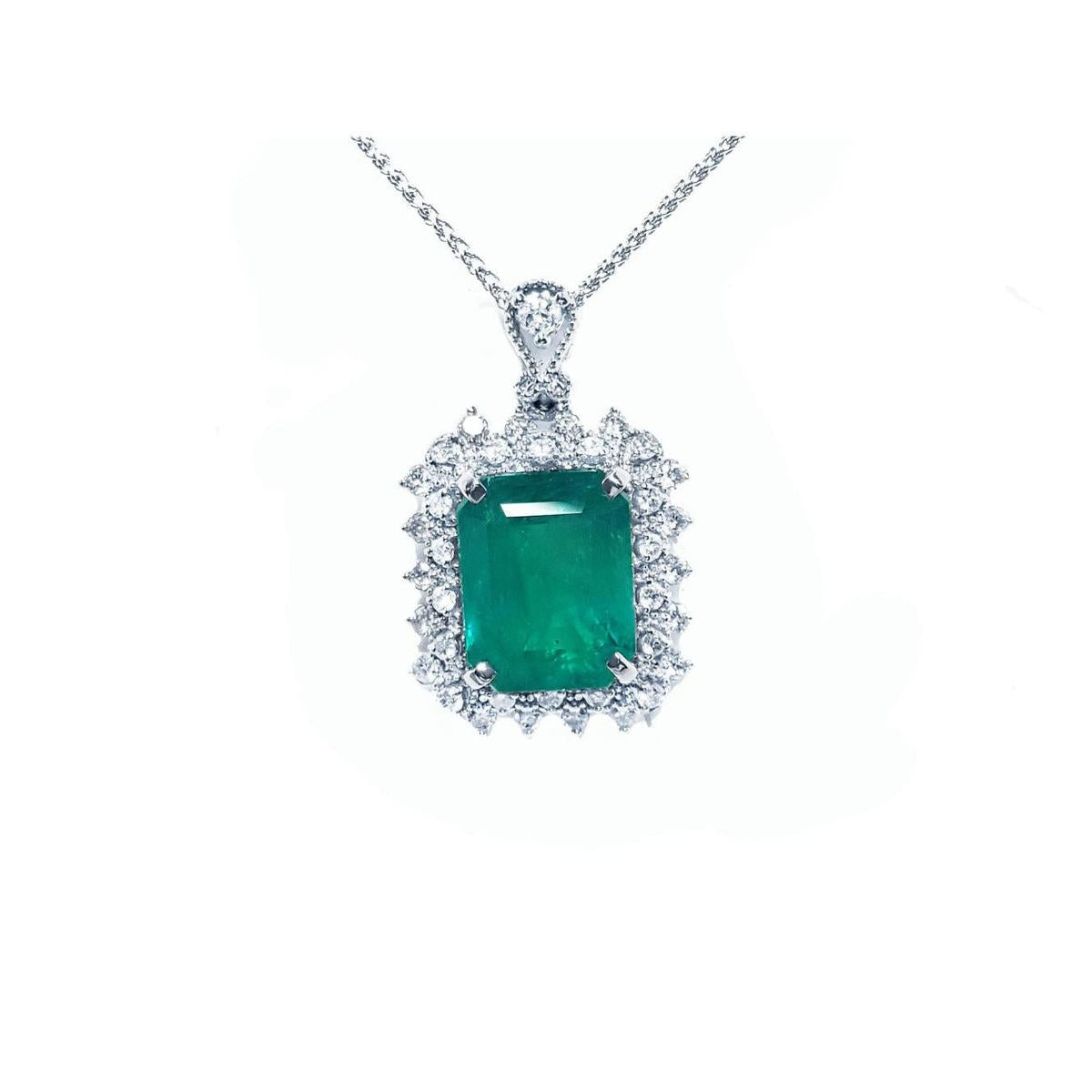A Muzo mine emerald pendant necklace with a halo diamond on a white gold chain topside view