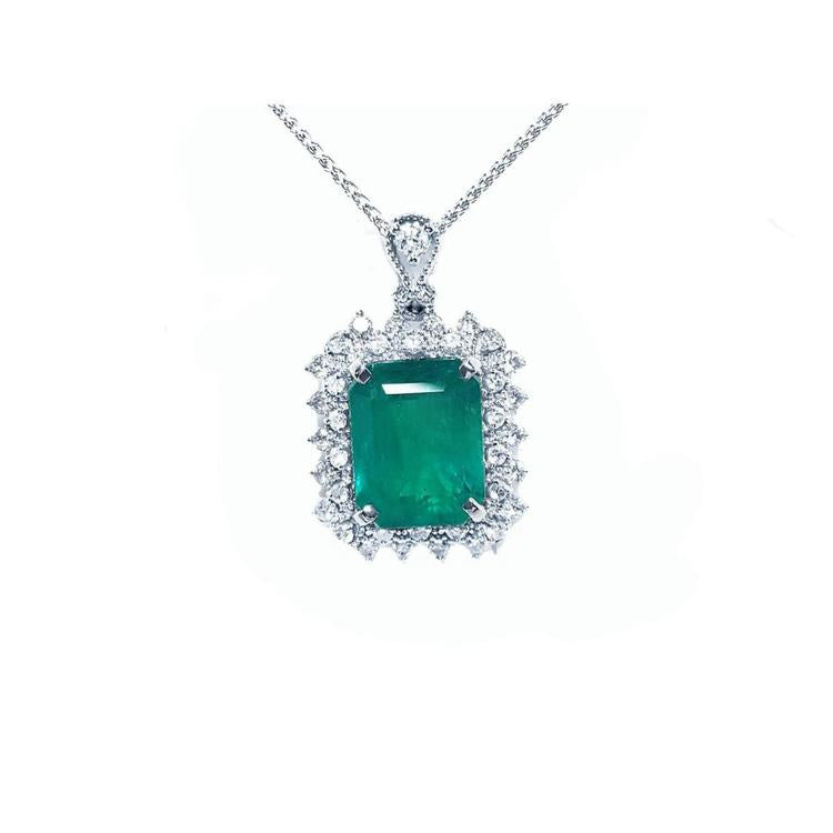 A Muzo mine emerald pendant necklace with a halo diamond on a white gold chain topside view