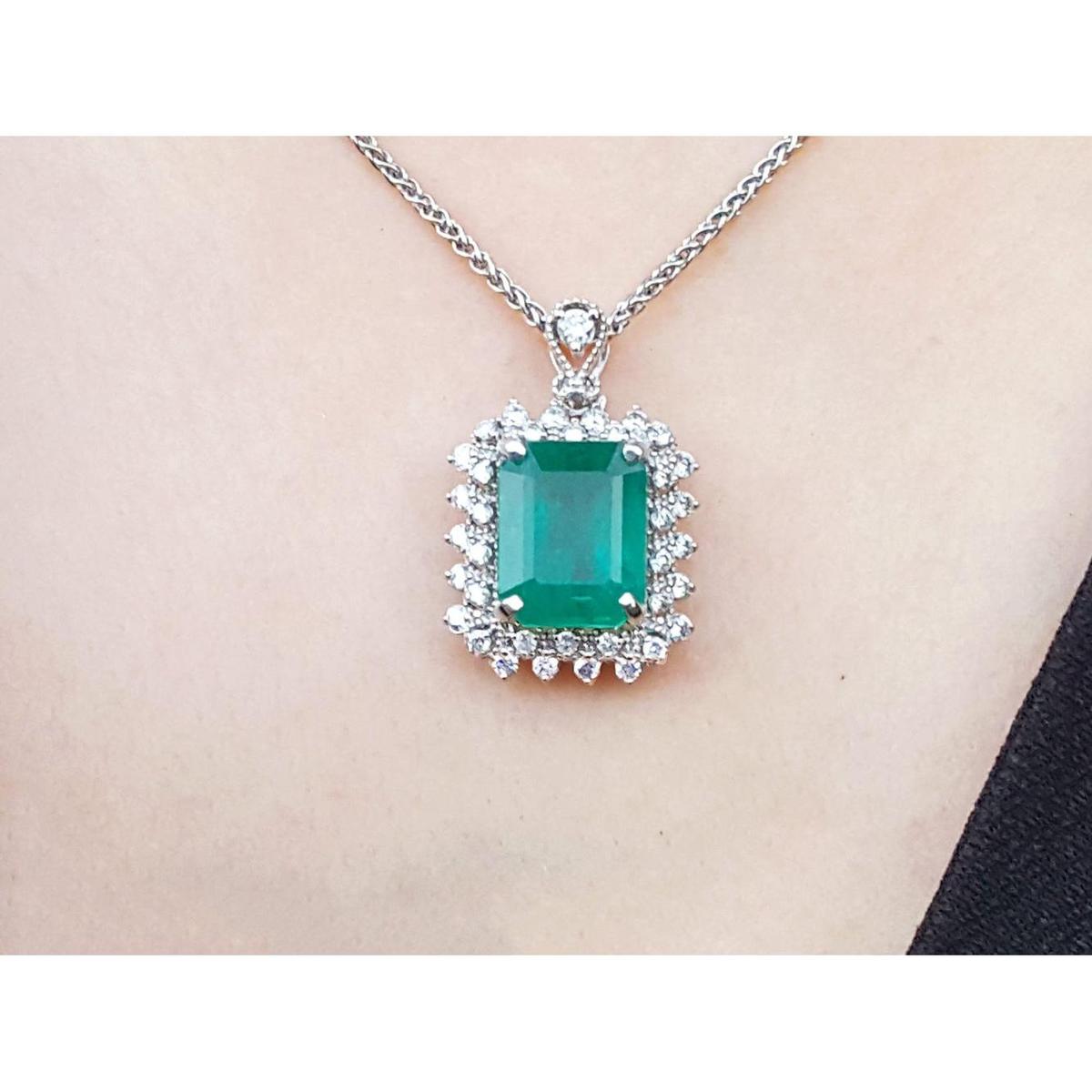 Emerald pendant necklace halo diamond on a white gold chain, skin background