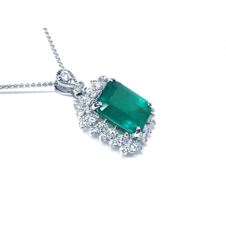 7.78 ct. deep green rectangular emerald pendant with double halo diamonds on a 14K white gold chain.