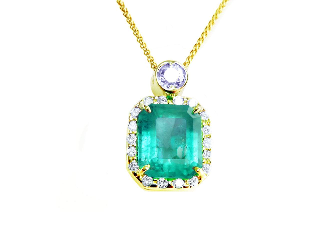 The topside view of a natural colombian emerald square shape surrounded by a halo diamond, made of 18k yellow gold.