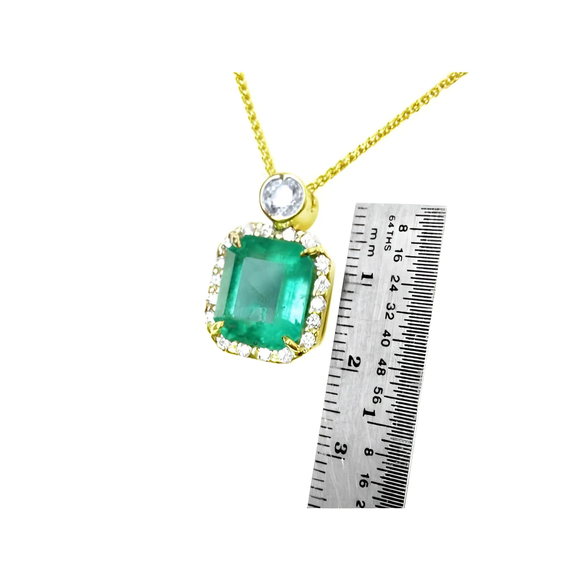 7.09 ct natural emerald pendant necklace with halo diamonds in 18K yellow gold, shown with a ruler for size.