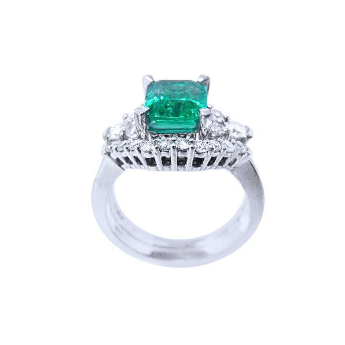 The white gold matching band with diamonds lateral profile in front of the emerald engagement ring.