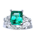 The topside view of the emerald and side diamonds ring whit the match wedding band in white gold.