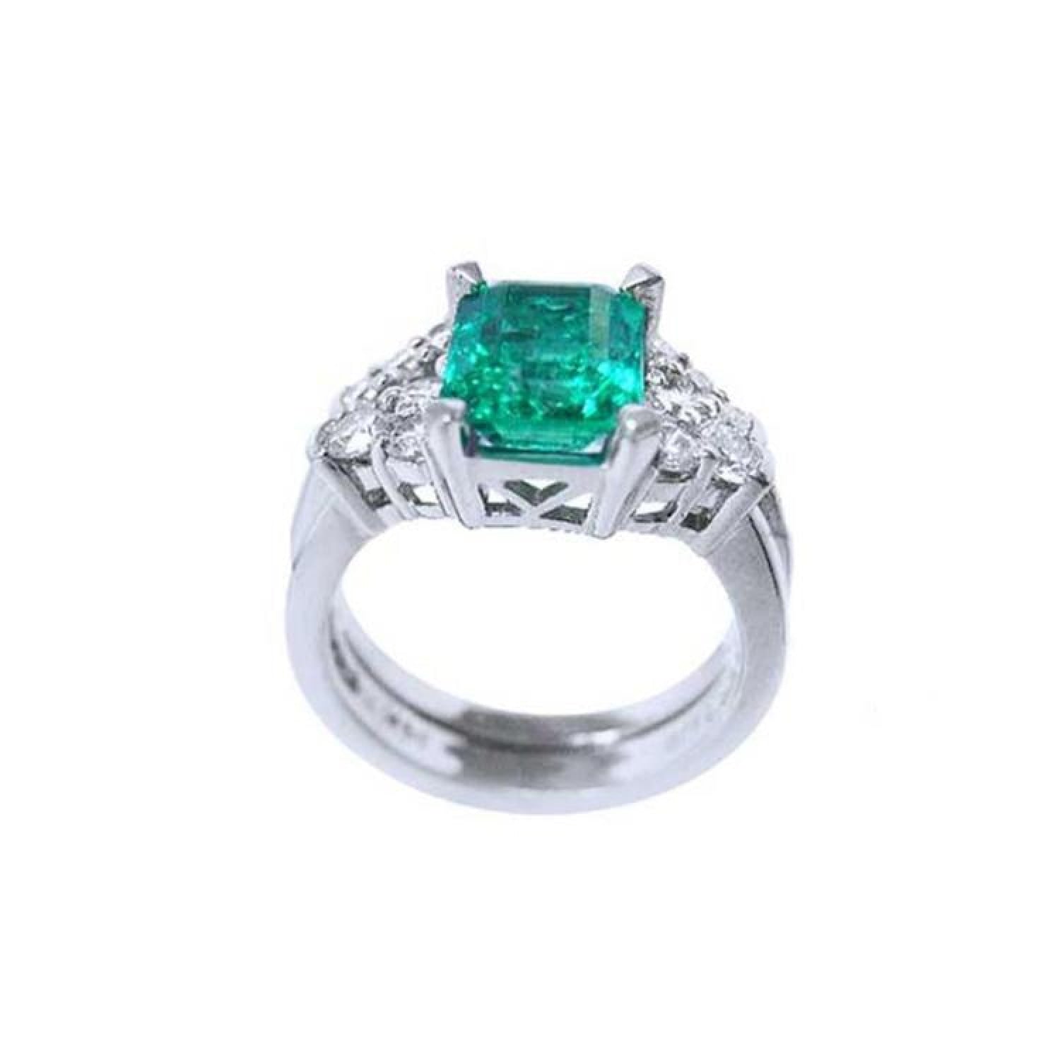 Emerald-cut vivid bluish green emerald ring with diamond accents and matching white gold band.