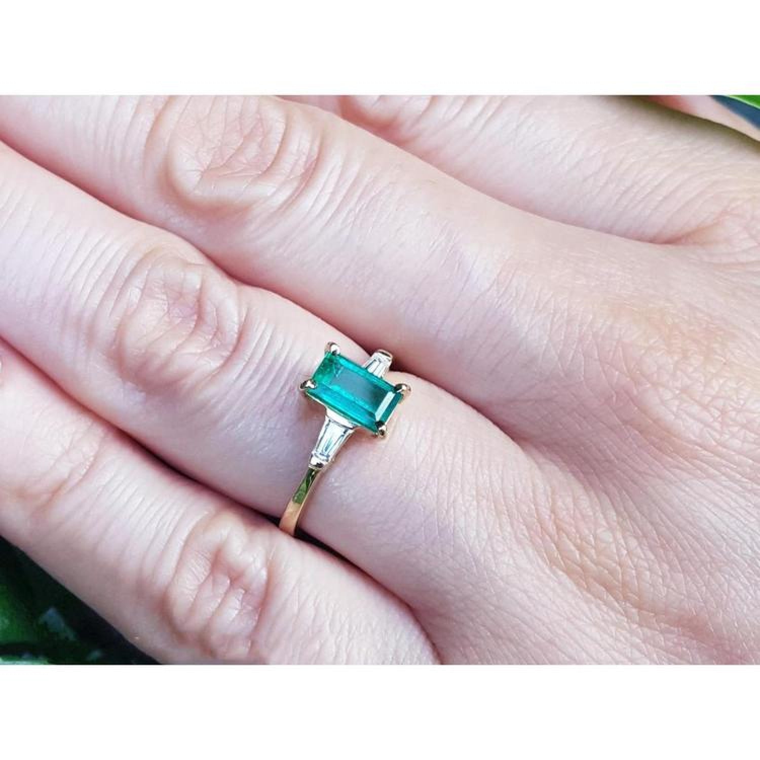 1.05 ct natural emerald ring with side baguette diamonds in 14K yellow gold.