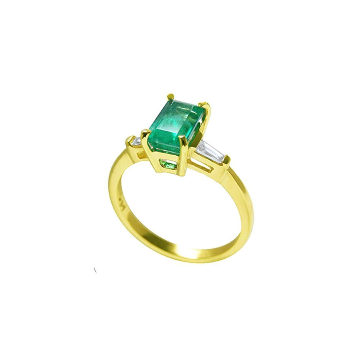 A 14k yellow gold ring with a genuine emerald side profile on a white background.