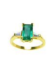 14k yellow gold ring with a center colombian emerald and two side baguette diamonds.