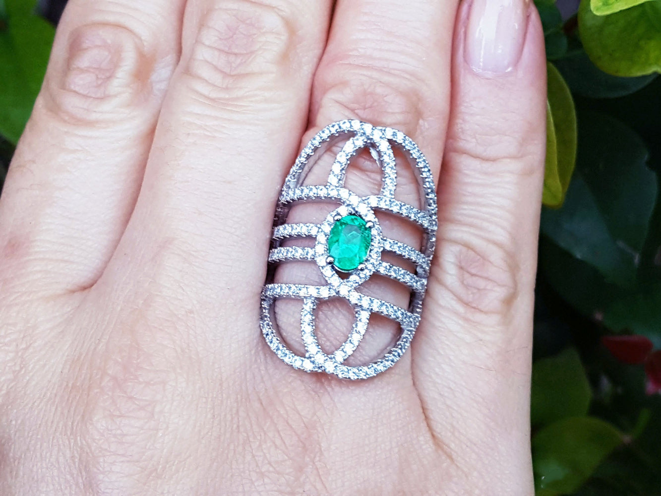 Silver ring with a green fire colombian emerald on a hand, branded &#39;Emeralds &amp; Jewelry Corp&#39;.