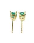 A pair of emerald stud earrings in 14k yellow gold, underside profile view.