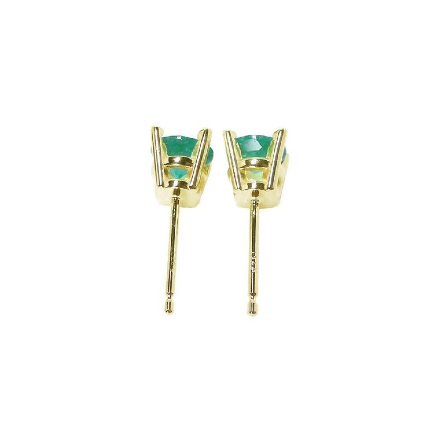 A pair of emerald stud earrings in 14k yellow gold, underside profile view.
