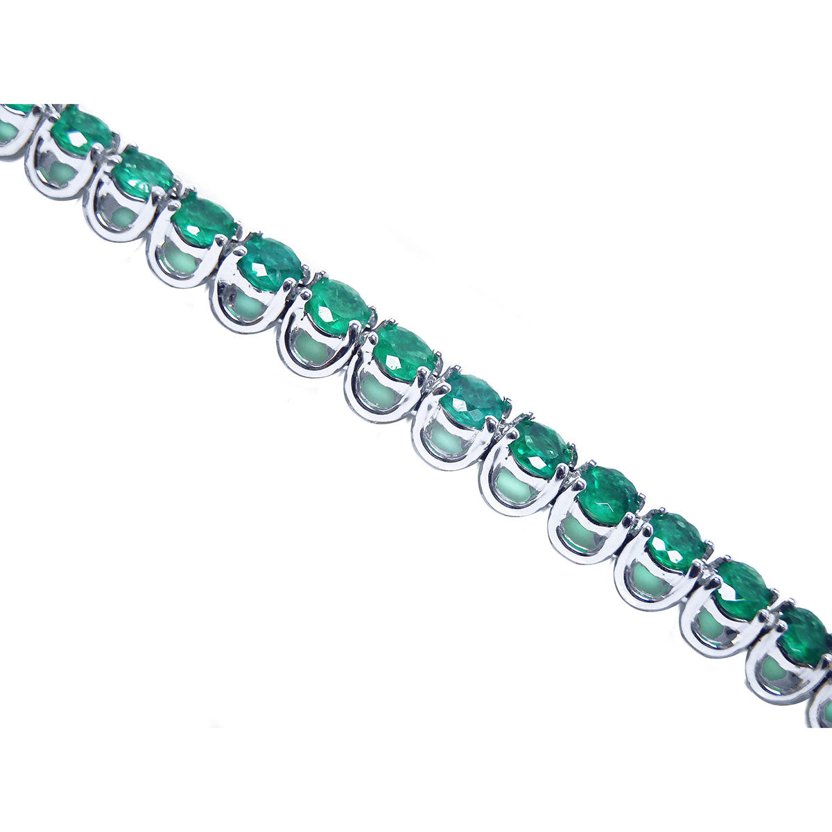 A tennis bracelet with round cut natural colombian emeralds in 14k white gold showing the side profile view.
