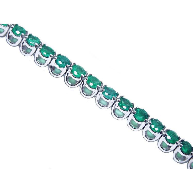 A tennis bracelet with round cut natural colombian emeralds crafted in in 14k white gold.