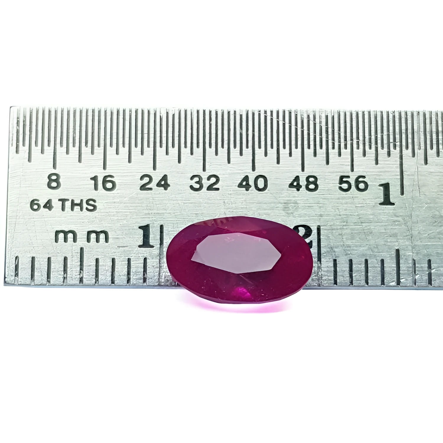 2.12 carat loose natural oval-cut ruby gemstone with rich red color, displayed on a ruler.