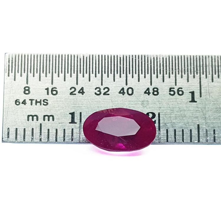 2.12 carat loose natural oval-cut ruby gemstone with rich red color, displayed on a ruler.
