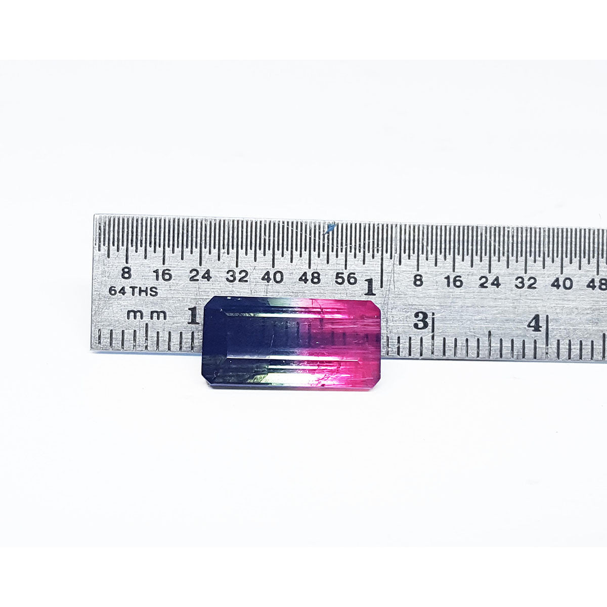 Rectangular Brazilian tourmaline with pink and blue gradient on a ruler for scale.
