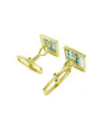Gold square-shaped cufflinks with natural colombian emeralds on a white background.