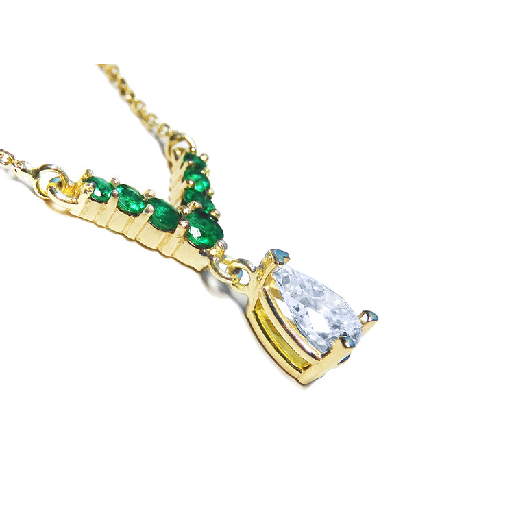 Natural pear cut diamond with emeralds necklace dangling from a V style center piece with natural round cut emeralds