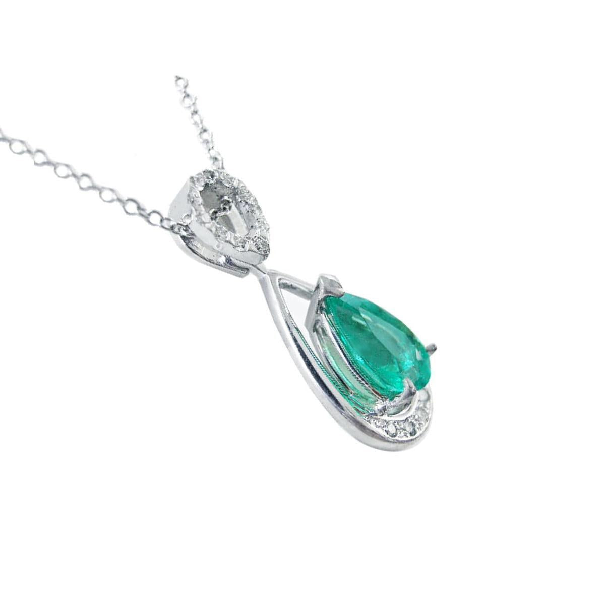 White gold pendant with a natural colombian emerald on a white background.